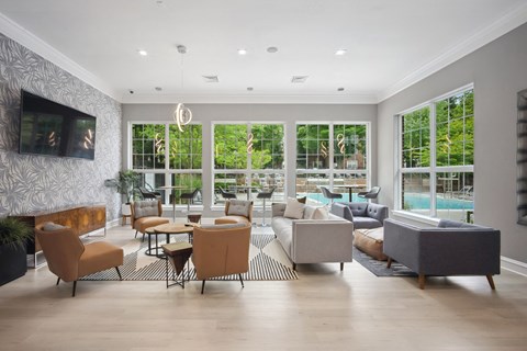 A living room with a television and a pool outside the window.