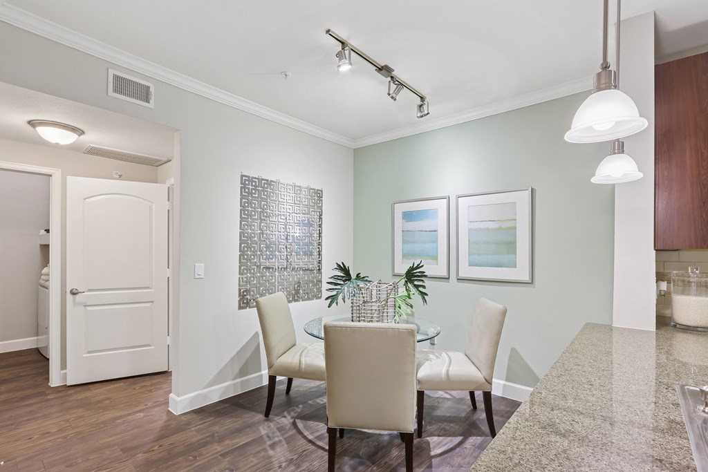 A dining room with a glass table and chairs.
