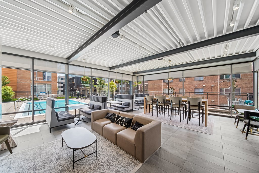 A modern living room with a pool outside the window.