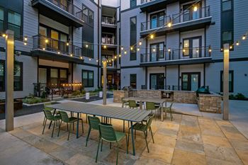 an outdoor patio with tables and chairs at The Penroseapartments