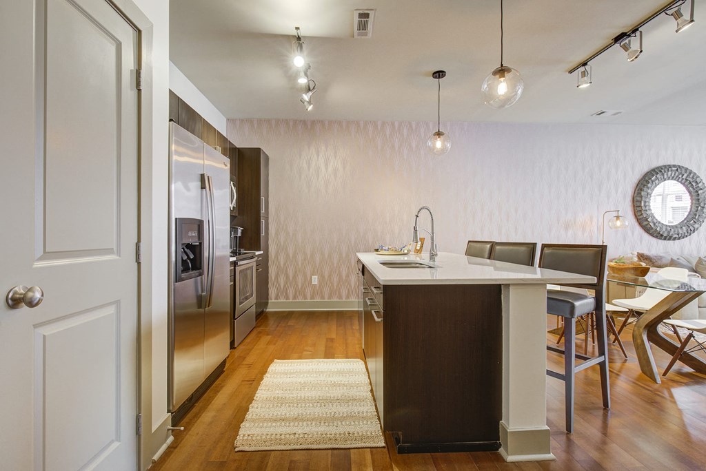 a kitchen with an island and a stainless steel refrigerator