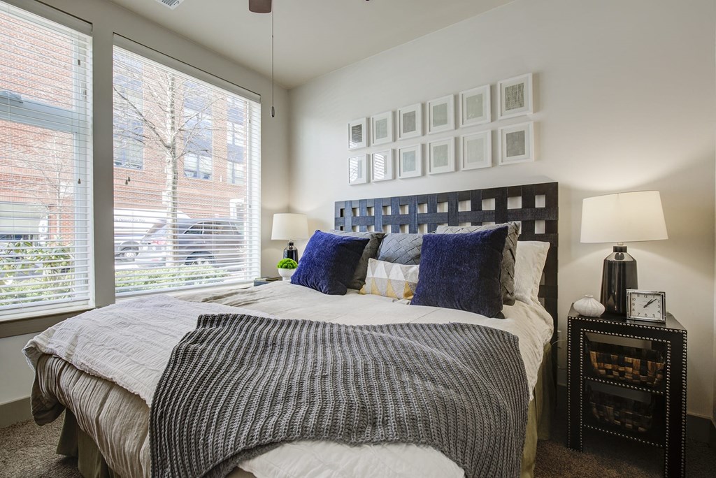 a bedroom with a bed and a large window