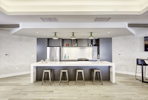 A modern kitchen with a white island and stools.