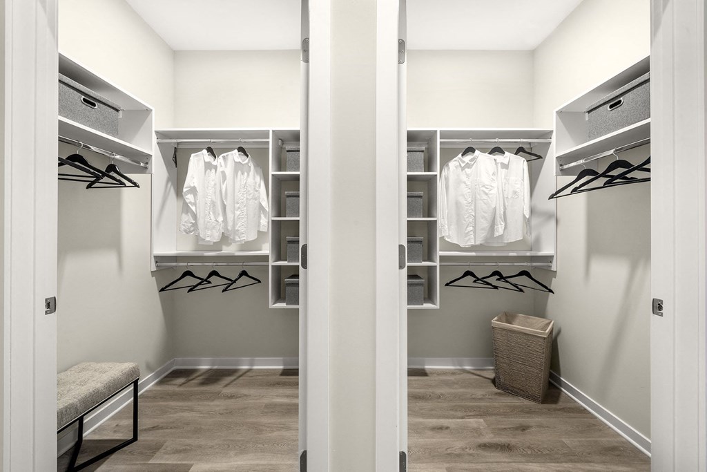 a walk in closet with white closets and racks and a closet door open at The Ivy, Chatham, 07928
