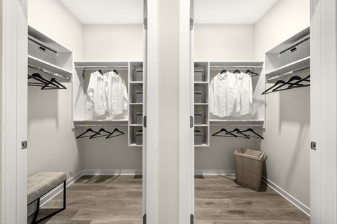 a walk in closet with white closets and racks and a closet door open at The Ivy, Chatham, 07928
