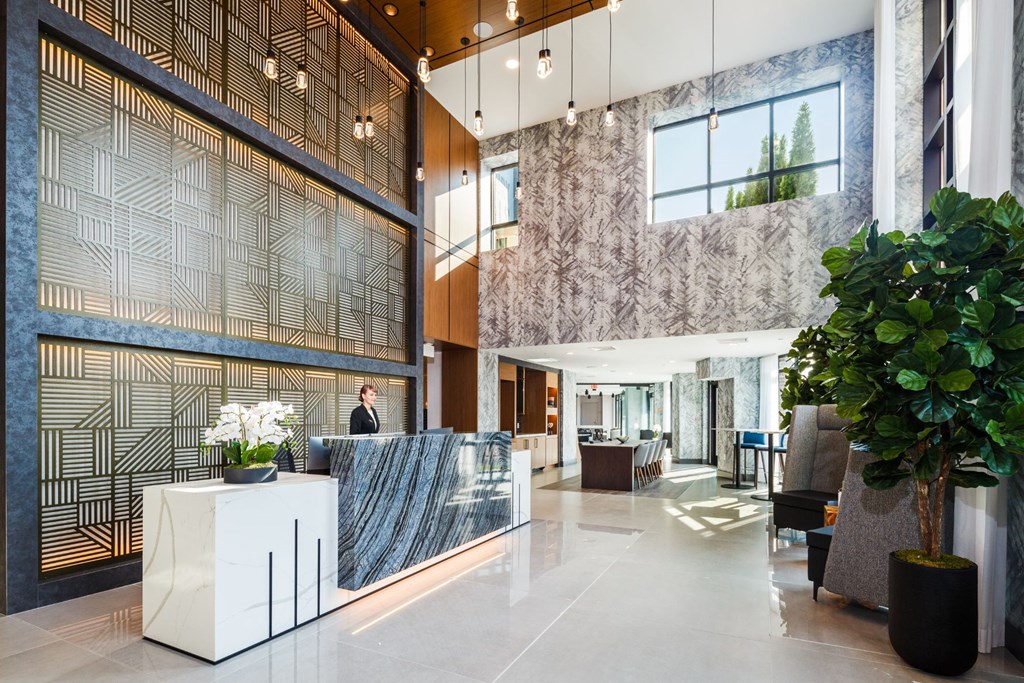 a lobby with a reception desk and a large plant at 100 House Apartments, New Jersey