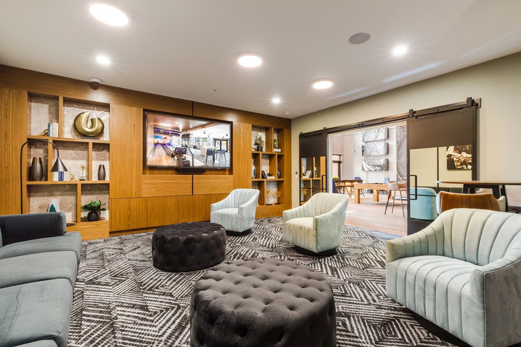 a living room with couches and chairs and a television at 100 House Apartments, Jersey City , NJ