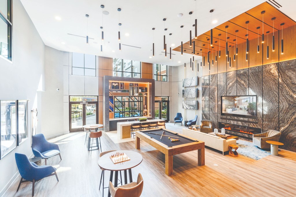 a living room with a fireplace and a pool table at 100 House Apartments, Jersey City