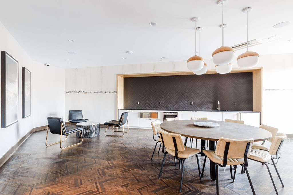 a dining room with a round table and chairs and a kitchen at 100 House Apartments, New Jersey, 07310
