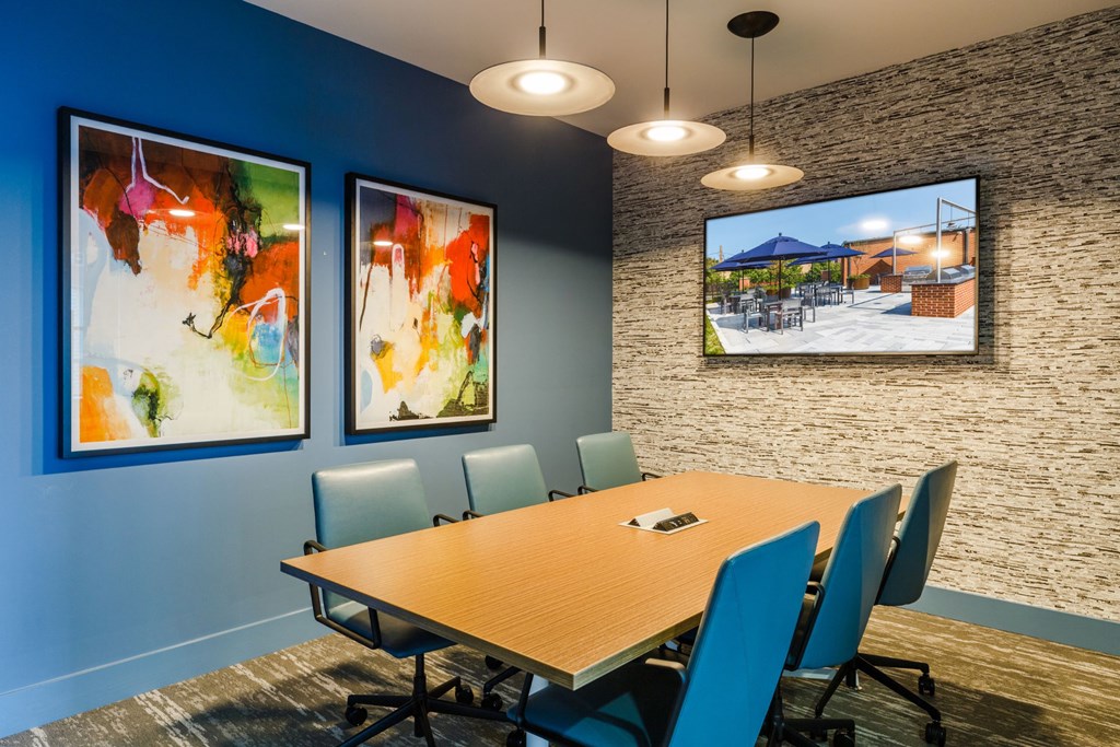 a conference room with a table and chairs and pictures on the wall at 100 House Apartments, New Jersey