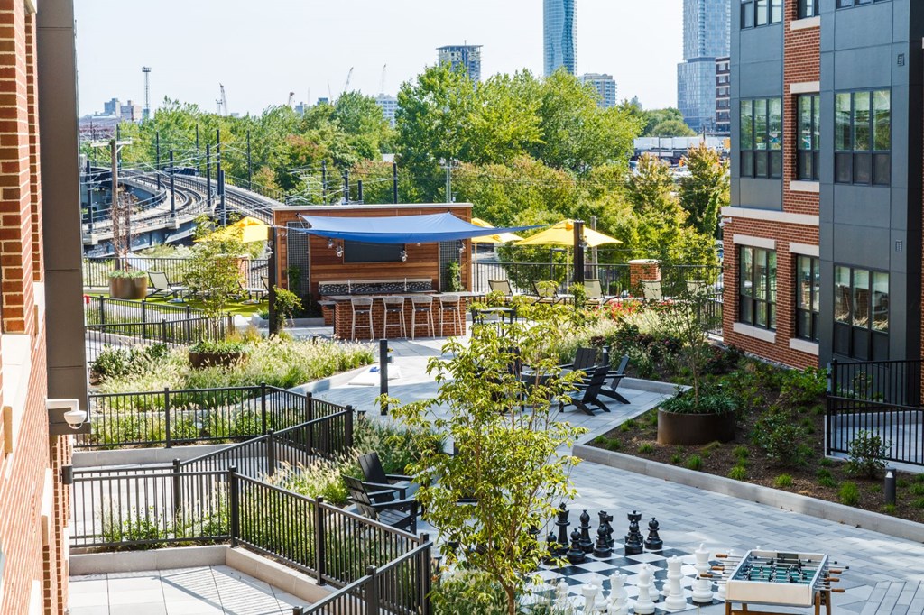 a view of the courtyard of a building with benches and tables at 100 House Apartments, Jersey City , NJ, 07310
