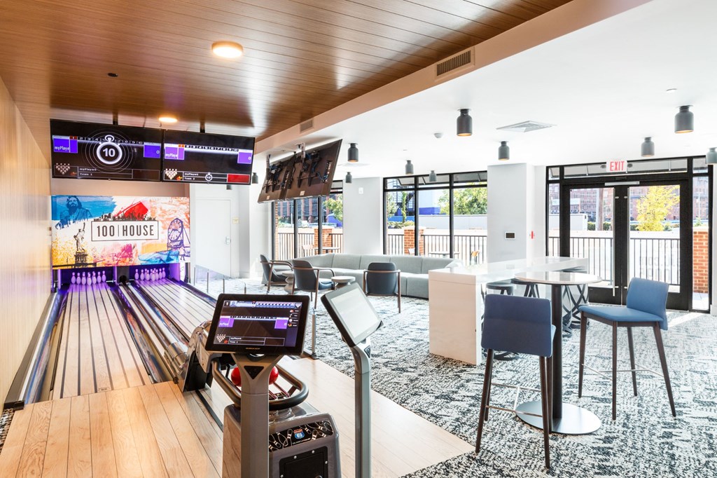 a bowling alley in a bowling club with tables and chairs at 100 House Apartments, Jersey City , NJ
