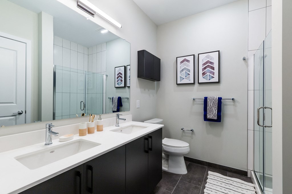 a bathroom with two sinks and a shower and a toilet at 100 House Apartments, New Jersey