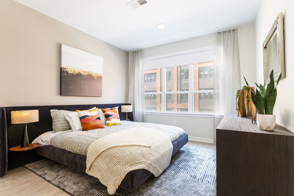 a bedroom with a bed and a large window at 100 House Apartments, New Jersey, 07310