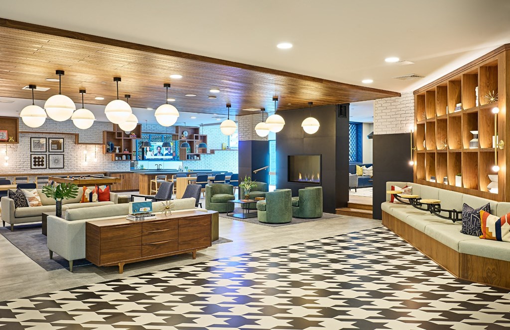 a lobby of a hotel with couches and chairs and a fireplace