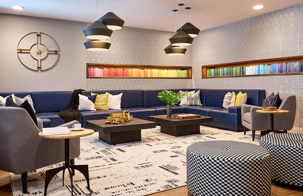 a lobby with blue couches and tables and a clock on the wall