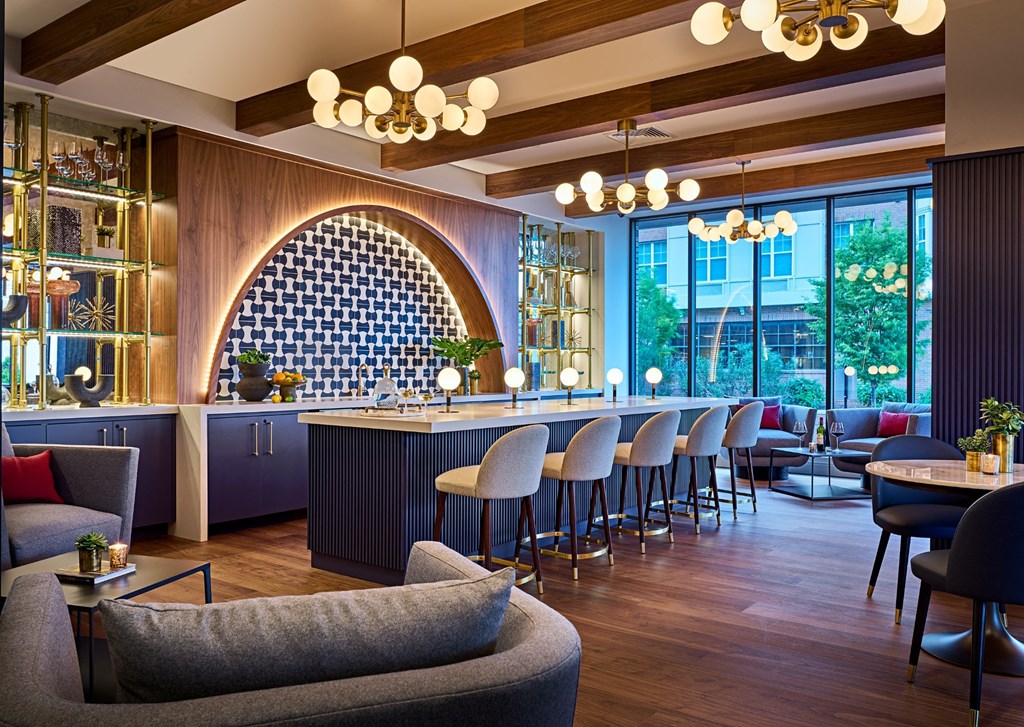 the lobby of a hotel with a bar and tables and chairs