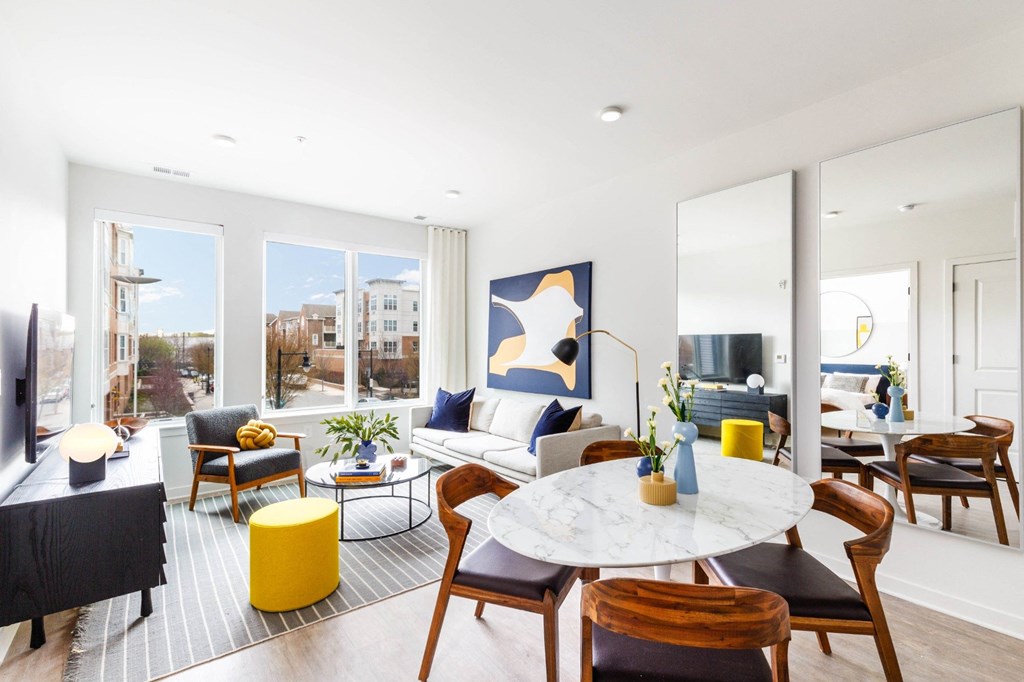 a living room with a table and chairs and a large window