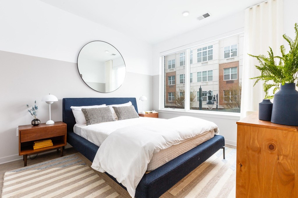 a bedroom with a bed and a large window