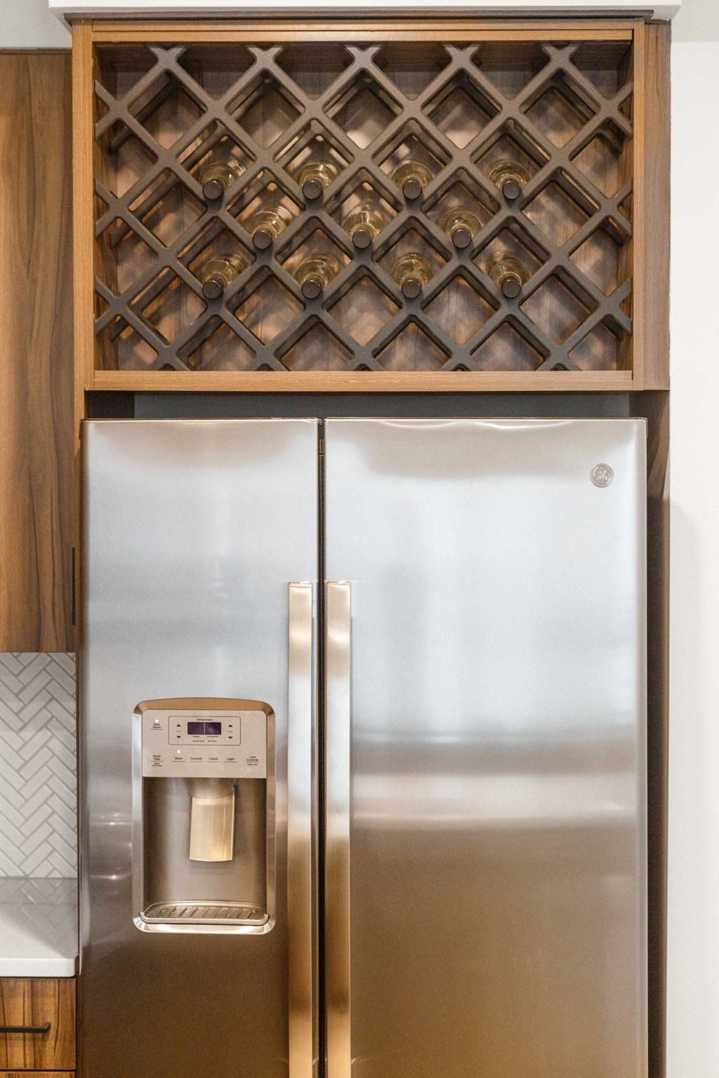 a kitchen with stainless steel appliances and a cabinet with a refrigerator