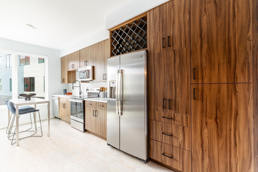 a kitchen with wooden cabinets and a stainless steel refrigerator