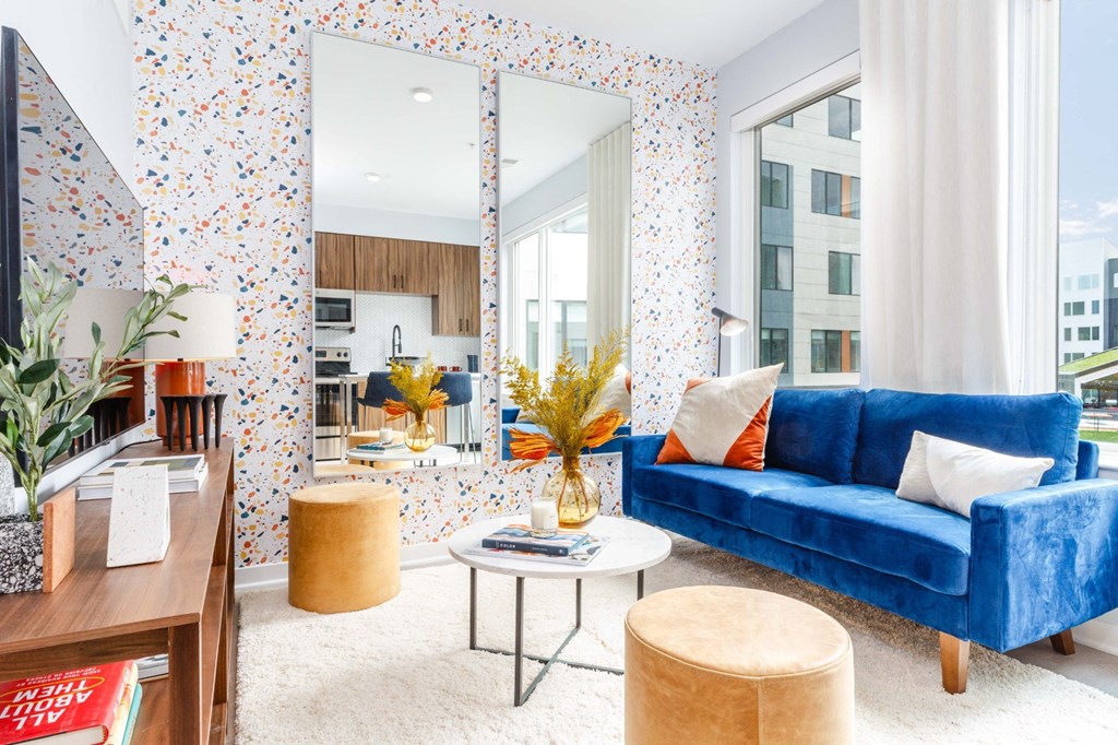 a living room with a blue couch and a large mirror
