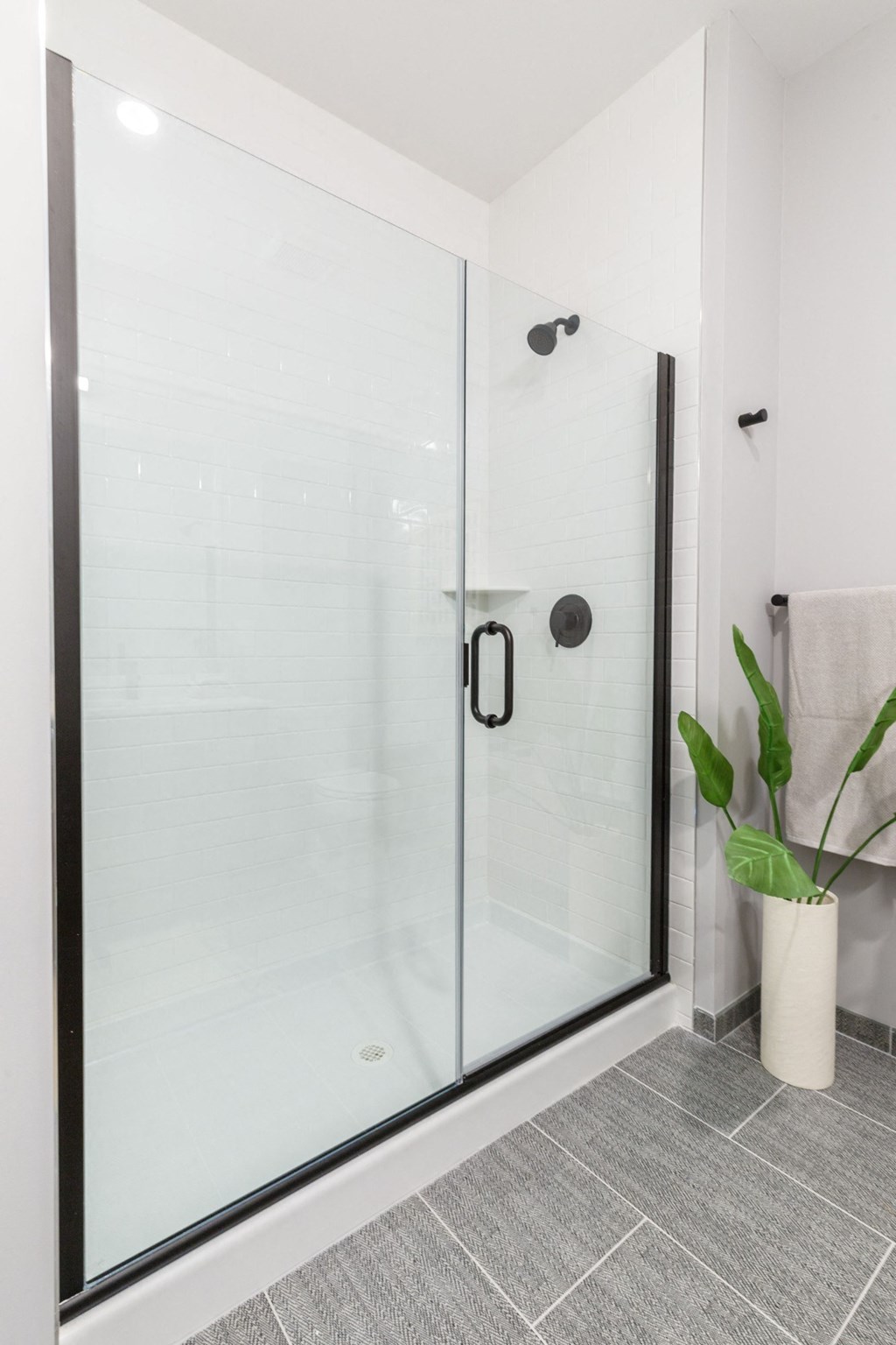a large glass shower in a white bathroom
