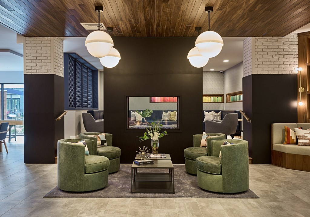 a living room with green chairs and a television