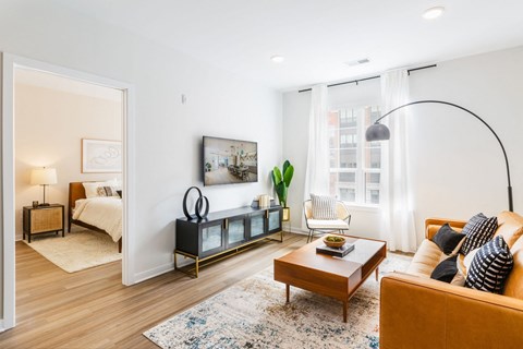 a living room with a couch and a coffee table    and a bedroom at One Ten Apartments, Jersey City , NJ