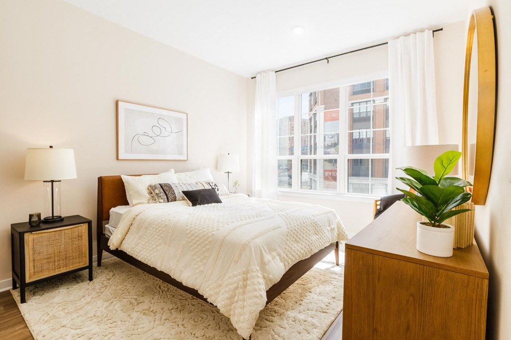 a bedroom with a bed and a large window a bedroom with a bed and a large window at One Ten Apartments, New Jersey, 07310