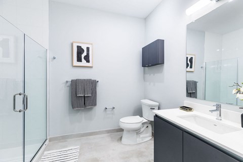 a bathroom with a toilet and a sink and a shower at One Ten Apartments, New Jersey