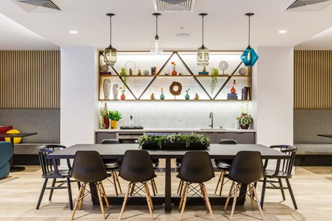 a dining area with a table and chairs and a kitchen in the background at One Ten Apartments, New Jersey, 07310