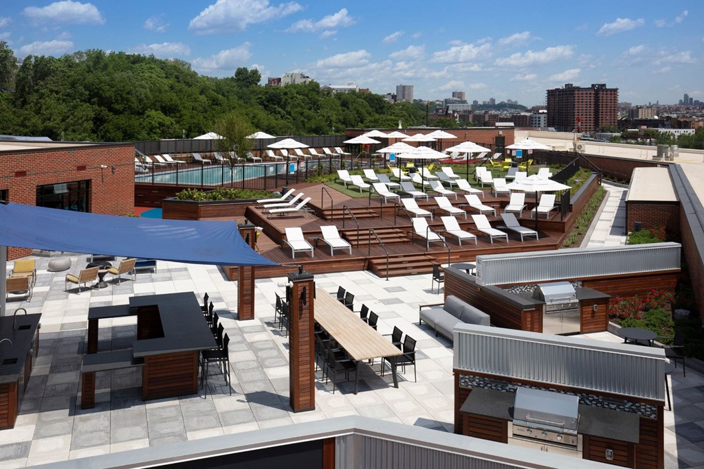 an aerial view of the rooftop lounge area of a hotel with lounge chairs and tables