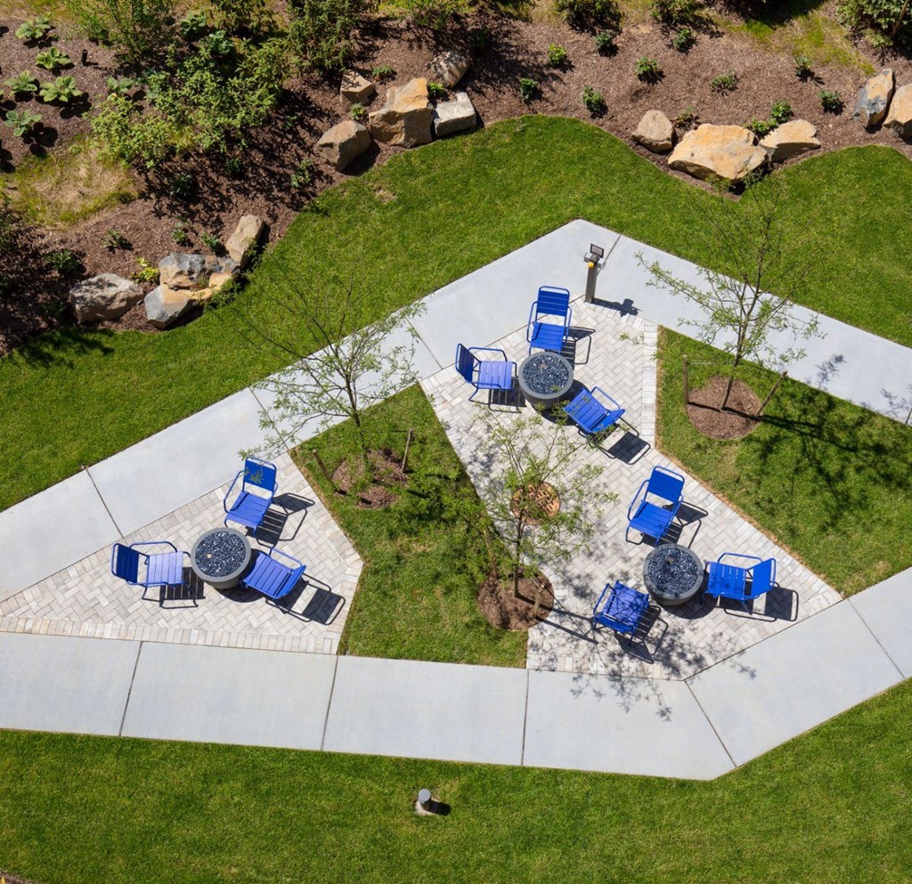 a patio with blue chairs and tables in a park