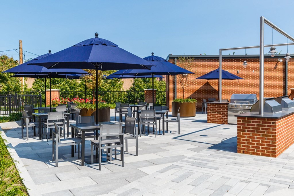 a patio with blue umbrellas and tables with chairs