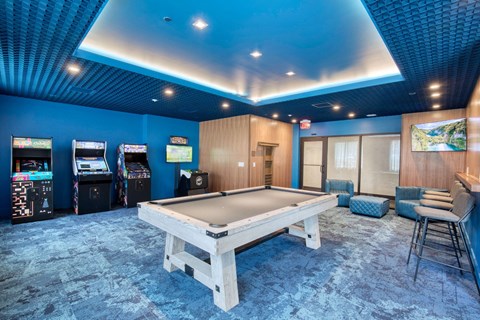 a game room with a pool table and arcade machines at One Ten Apartments, Jersey City , NJ