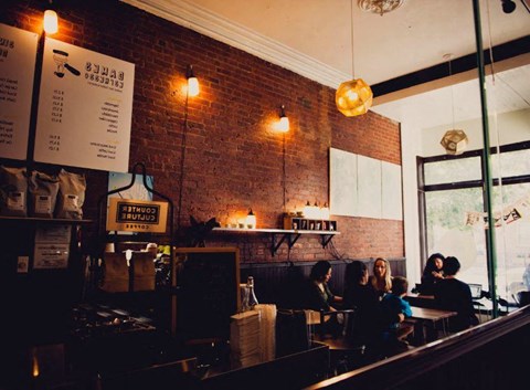 a group of people sitting at tables in a restaurant at One Ten Apartments, Jersey City , NJ