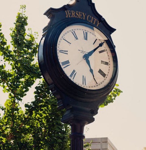 a large clock on top of a pole at One Ten Apartments, Jersey City , New Jersey