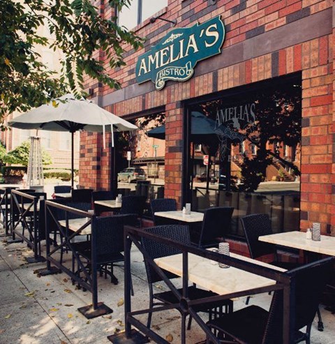 the outside of a restaurant with tables and chairs at One Ten Apartments, Jersey City