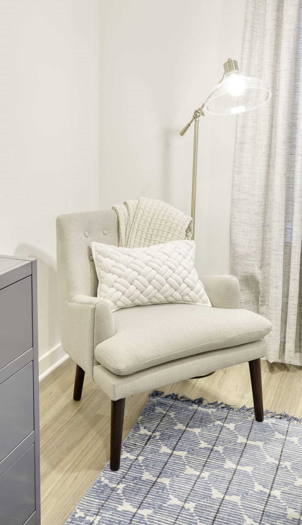 a chair with a pillow and a lamp in a room