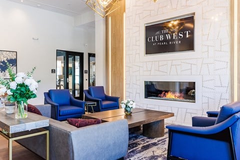 the club west living room with blue chairs and a fireplace