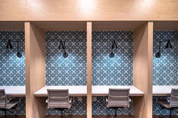 a conference room with two tables and chairs and blue and white wallpaper at The Grove at Piscataway
