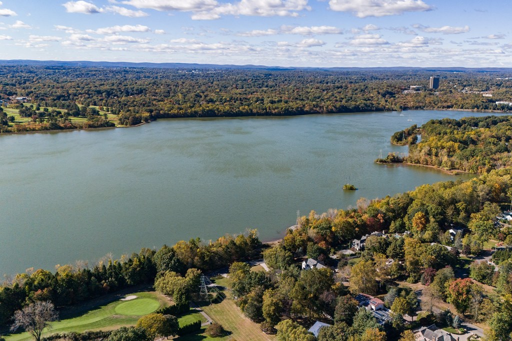 A large body of water surrounded by trees and buildings at The Reserve at Pearl River Apartments, Pearl River, NY, 10965
