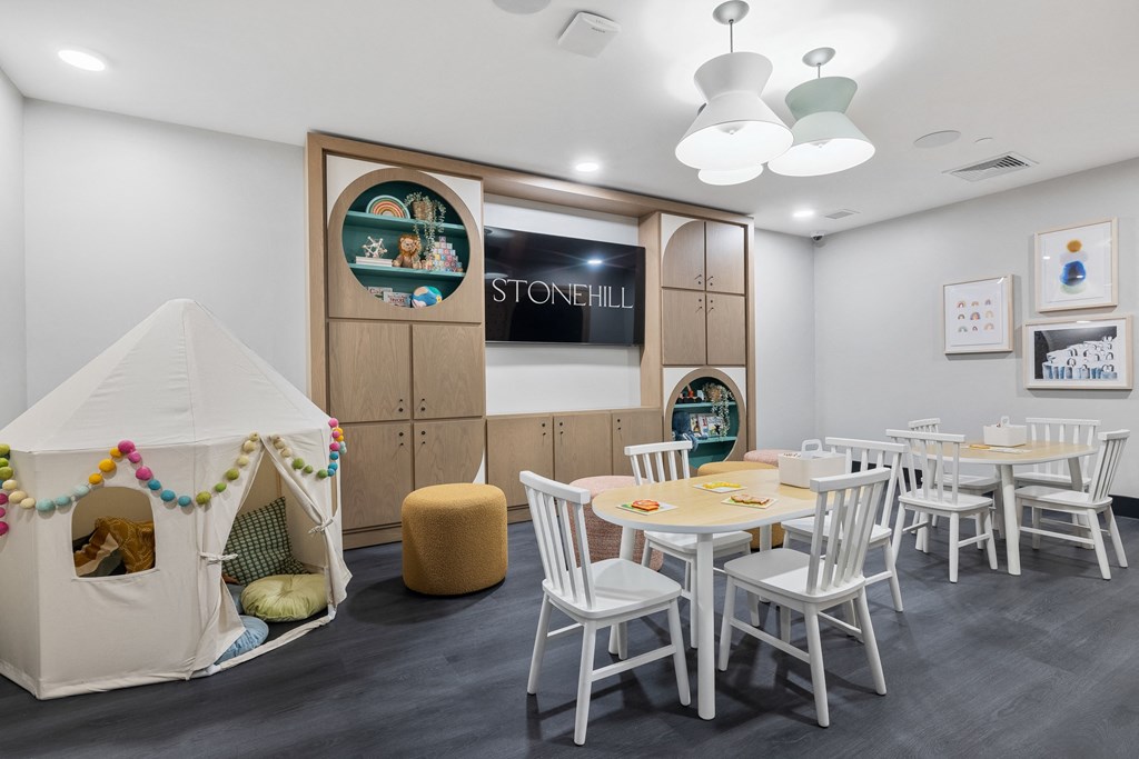 a play room with a table and chairs and a tent