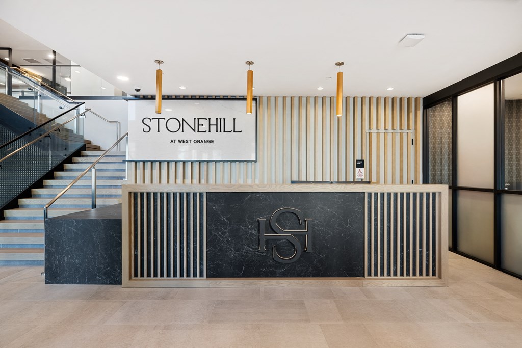 the lobby with stairs and a stonhill sign