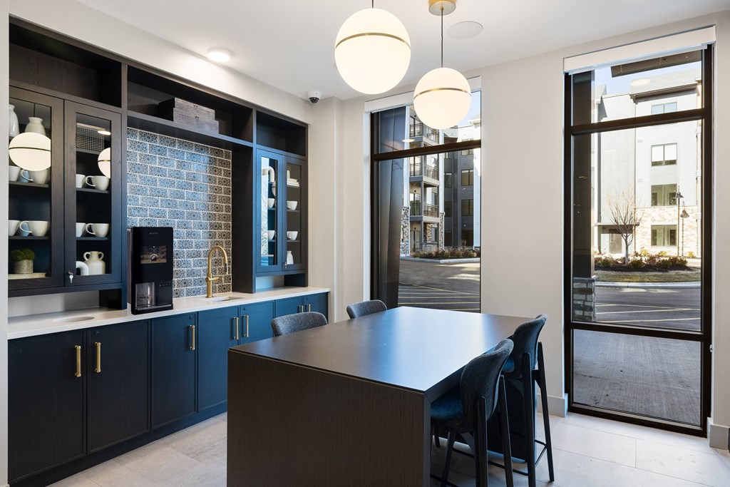 a kitchen with blue cabinets and a long island with blue chairs