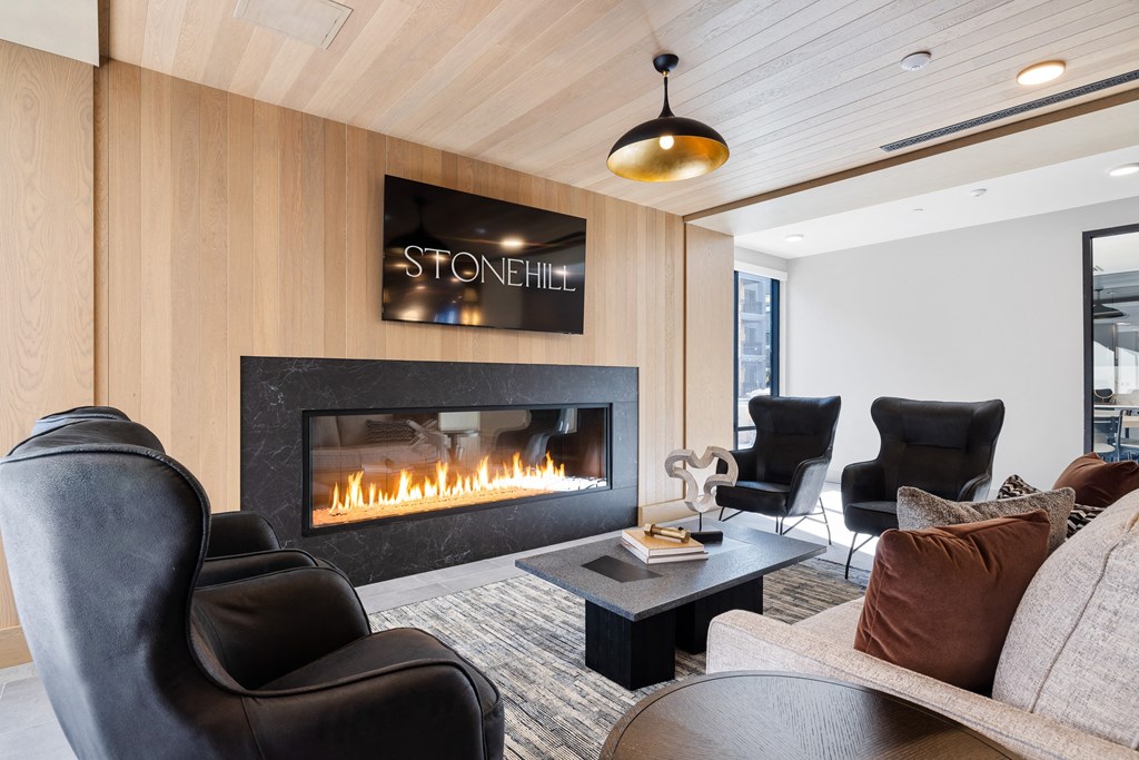 a living room with leather chairs and a fireplace