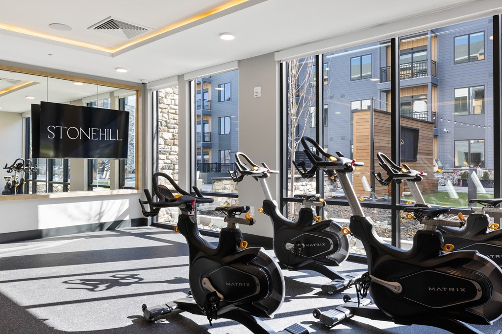 a gym with several exercise bikes in front of a window