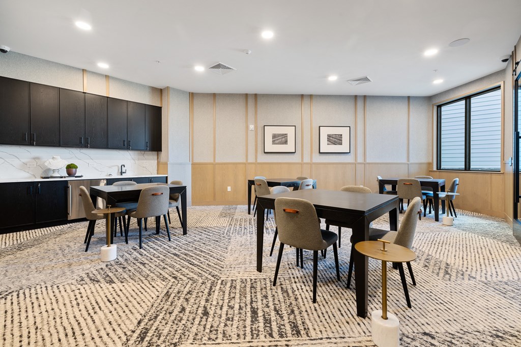 a conference room with tables and chairs and a kitchen