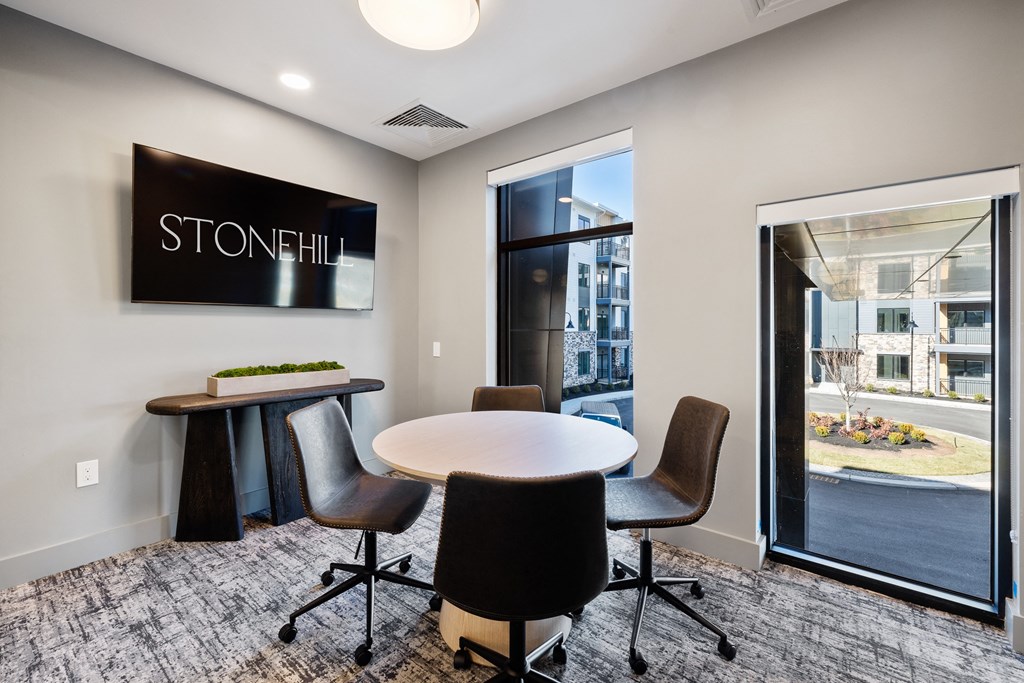 a conference room with a table and chairs in front of a window